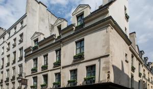 um grande edifício branco com vasos de plantas sobre ele em Charles V em Paris