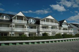 オストゼーバート・カールスハーゲンにあるHafenidyll mit Wasserblickの白いバルコニー付きの広い白いアパートメントです。