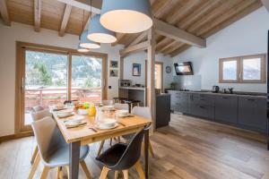 cocina y comedor con mesa de madera y sillas en Chalet De L'ours - Chamonix All Year, en Chamonix-Mont-Blanc