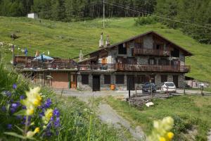 une maison en bois avec un balcon sur une colline dans l'établissement Grand Golliat, à Saint-Rhémy-en-Bosses