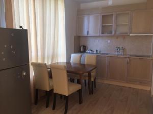 a kitchen with a table and chairs and a refrigerator at Guest House ASK in Primorsko