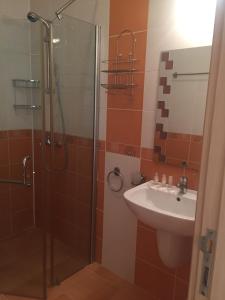 a bathroom with a glass shower and a sink at Guest House ASK in Primorsko