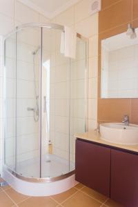 a bathroom with a glass shower and a sink at Vila Barca in Madalena