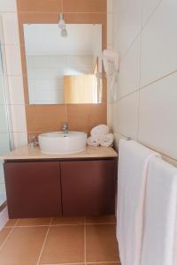 a bathroom with a sink and a mirror and towels at Vila Barca in Madalena