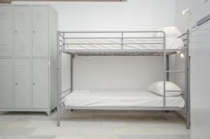 a bunk bed in a room with white walls at Hostel Naxos Camping in Naxos Chora +14 photos