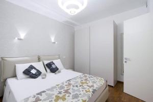 ein Schlafzimmer mit einem weißen Bett mit zwei Kissen darauf in der Unterkunft Central STEMA Luxury in Misano Adriatico