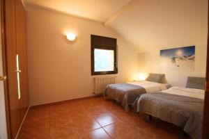 a hotel room with two beds and a window at Pont de Toneta 6,3 Atico Duplex, Ransol, Zona Grandvalira in Ransol