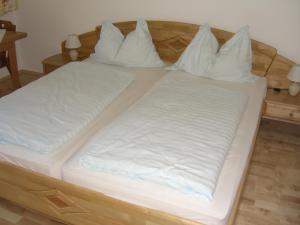 a bed with white sheets and pillows on it at Haus Söllner in Lend