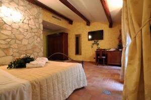 a bedroom with a bed and a stone wall at Hotel L'Aquila in LʼAquila