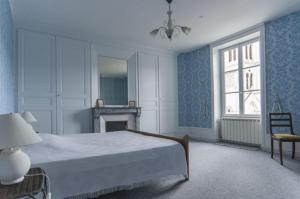 a blue bedroom with a bed and a fireplace at Les Volets Bleus in Le Perréon