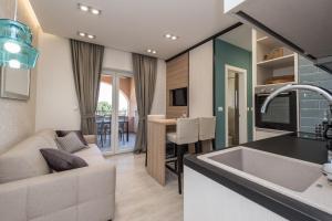 uma cozinha e sala de estar com um sofá e um lavatório em Luxury Apartments Garden em Sukošan