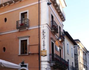 
a building that has a clock on the side of it at Hotel L'Aquila in LʼAquila
