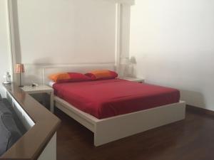 ローマにあるVatican City House Romaのベッドルーム1室(赤いシーツとオレンジの枕が備わるベッド1台付)