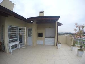 a house with a large patio with a balcony at Apartamento no Residencial Amazônia I in Florianópolis