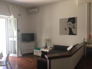 Una sala de estar con un sofá y un televisor. en Vatican City House Roma, en Roma