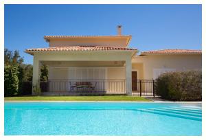 une maison avec une piscine en face d'une maison dans l'établissement Villa 4 étoiles Sole di Corsica, à Cauro