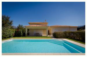 une villa avec une piscine en face d'une maison dans l'établissement Villa 4 étoiles Sole di Corsica, à Cauro
