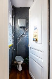 a bathroom with a toilet and a wall with graffiti at Veeve - Balcony Bliss in Paris