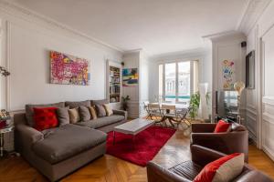 sala de estar con sofá y alfombra roja en Veeve - Balcony Bliss, en París