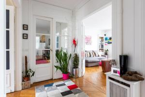 Sala de estar blanca con sofá y puerta en Veeve - Balcony Bliss, en París