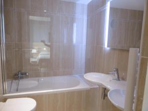 a bathroom with a tub and two sinks and a shower at Hôtel La Flore in Villefranche-sur-Mer