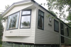 a tiny house on a trailer with windows at The Valley Static Caravan in Pembrokeshire
