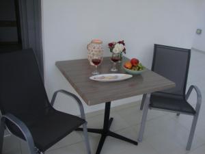 drewniany stół z 2 krzesłami i miską owoców w obiekcie Studio Vasileios-The Best Luxury Guest Room in Spili w mieście Spílion