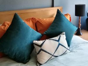 Duas almofadas verdes em cima de uma cama em Rain​ Cha​ Am​ -​ Hua​ ​Hin​ by​ Good​ Luck​ Home em Cha Am