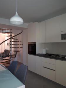 a kitchen with white cabinets and a table and chairs at Kuća za odmor Pende in Banjol