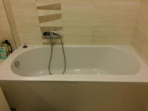 a white bath tub with a shower in a bathroom at Harmony in Sveti Stefan