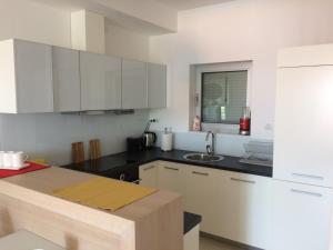 a kitchen with white cabinets and a sink at Harmony in Sveti Stefan