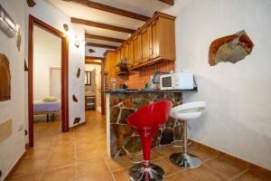 a kitchen with a red stool and a microwave at Casa Checa Apartment 2 in El Cotillo