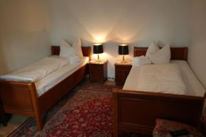 2 Betten in einem Zimmer mit 2 Lampen an Tischen in der Unterkunft Gästehaus Howe in Stade