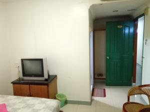 una camera con televisore e porta verde di HOTEL SUPER 888 a Tanjung Balai Karimun