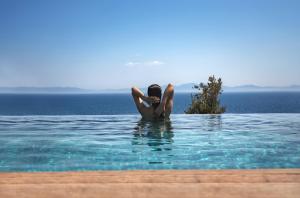 a woman laying in the water in a swimming pool at Six Senses Kaplankaya in Akbük