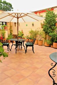 a patio with a table and chairs and an umbrella at Villa Mirasol in San Miguel de Allende