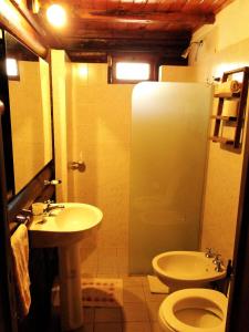 a bathroom with a toilet and a sink at X Sierras Cabañas in Villa Carlos Paz