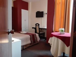 een hotelkamer met een bed en een tafel met een stoel bij Los Q'eros in Lima