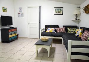 a living room with a couch and a tv at La Maison Des Invites in Pernes-les-Fontaines