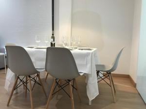 uma mesa de jantar com cadeiras e copos de vinho em Apartamentos Areas em Sanxenxo