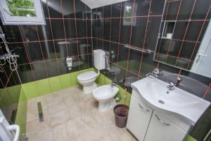 a bathroom with a white toilet and a sink at Apartments River 1 in Bihać +9 photos