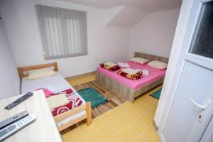 Habitación pequeña con 2 camas y ventana en Apartments River 1, en Bihać