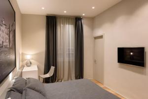 モンテヴァルキにあるPalazzo Vasarri - Luxury design suitesのベッドとテレビと窓のある寝室 +37枚の写真