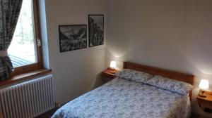 ピーラにあるAppartamento con terrazza a Pilaのベッドルーム1室(ベッド1台、窓、ランプ2つ付)