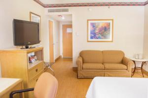 a living room with a couch and a tv at iStay Hotel Ciudad Victoria in Ciudad Victoria