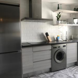 a kitchen with a refrigerator and a washing machine at Casa Anastasia I in Buendía +56 photos