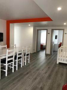 a dining room with a table and white chairs at PinoyHouse Fatima in Fátima