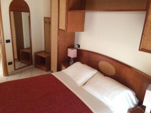 una camera con un grande letto con testiera in legno di Residence San Paolo a Lido di Savio