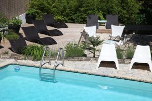 un grupo de sillas y una piscina en Hôtel La Paloma, en Hossegor