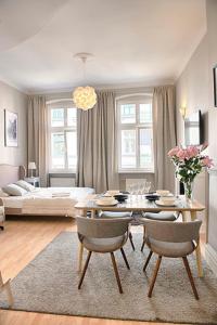 a living room with a table and chairs and a bed at Apartament Kopernika 25 in Toruń